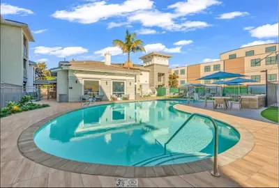 a swimming pool in the middle of a courtyard with a house at Spacious,2Queen beds, free parking, pool&gym and central location in Marina del Rey