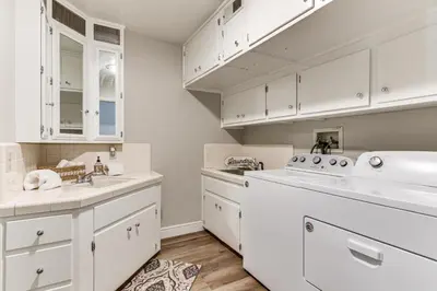 a kitchen with white cabinets and a dishwasher at Beautiful Kernville Home with Game Room and Mtn Views! in Kernville