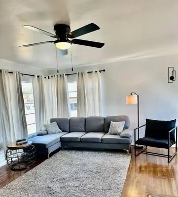 a living room with a blue couch and a ceiling fan at Modern La Cresta in Bakersfield