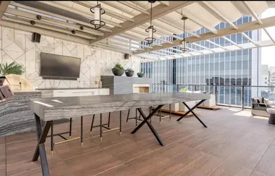 a large stone table in a large room with a tv at Hollywood Penthouse with Balcony & Pool View in Los Angeles