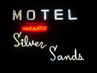 a neon sign that says moteel waamenny silver and sands at Silver Sands Motel in Ventura