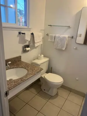 a bathroom with a toilet and a sink at Silver Sands Motel in Ventura