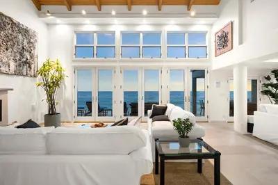 a living room with white furniture and a large window at Coastal Serenity in Malibu