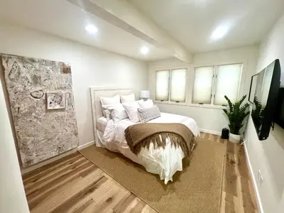 a bedroom with a bed with white sheets and pillows at Coastal Serenity in Malibu