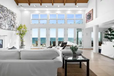 a living room with white furniture and large windows at Coastal Serenity in Malibu