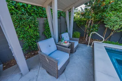 two wicker chairs sitting on a patio next to a swimming pool at Amazing days Spa Pool Villa near Disney & Beaches in Placentia