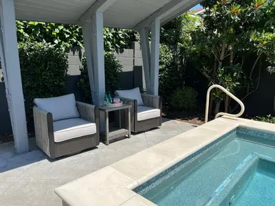 a patio with a table and chairs next to a swimming pool at Amazing days Spa Pool Villa near Disney & Beaches in Placentia