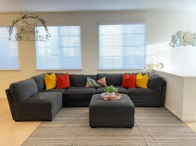 a living room with a gray couch with colorful pillows at Bella's sweet house 5640 in Eastvale