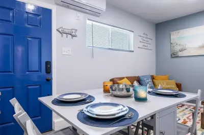 a dining room with a table and a blue door at Luxe and Modern South Bay ADU in Carson