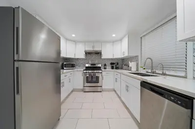 a kitchen with white cabinets and a stainless steel refrigerator at # Marbella Lane - Serene & Spacious 3BR Haven in West Covina