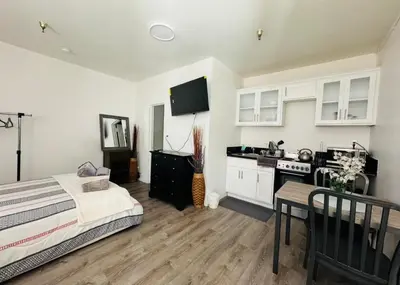 a bedroom with a bed and a kitchen with white cabinets at Sunset & La brea studio!! Best location ever in Los Angeles