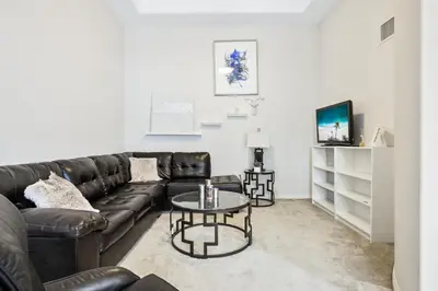 a living room with a leather couch and a table at Ultimate LA Vacation 2BR w Pool Above Shops in Monterey Park