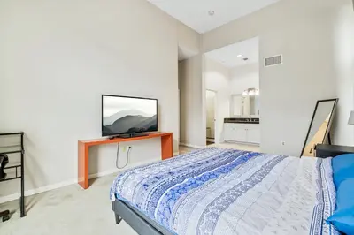 a bedroom with a bed and a flat screen tv at Ultimate LA Vacation 2BR w Pool Above Shops in Monterey Park