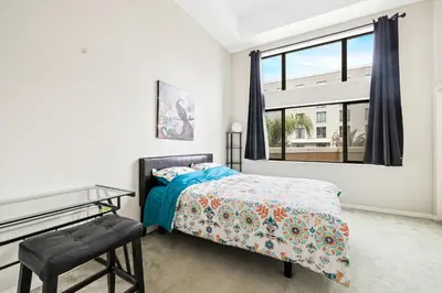 a bedroom with a bed and a desk and a window at Ultimate LA Vacation 2BR w Pool Above Shops in Monterey Park