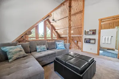 a living room with a couch and a staircase at Lakeview Lodge - Across the street from the lake and Boulder Bay Park! in Big Bear Lake
