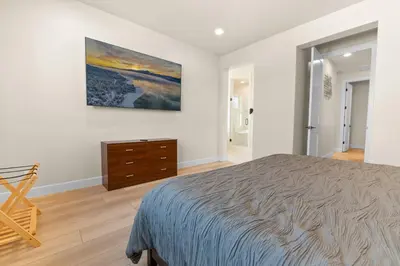 a bedroom with a bed and a painting on the wall at Pine Meadow - Game Room with pool table, foosball & shuffleboard! in Big Bear Lake