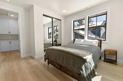 a bedroom with a bed and two windows at Pine Meadow - Game Room with pool table, foosball & shuffleboard! in Big Bear Lake