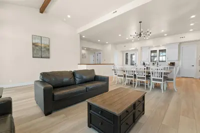 a living room with a couch and a table with chairs at Pine Meadow - Game Room with pool table, foosball & shuffleboard! in Big Bear Lake