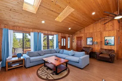 a living room with a couch and a table at North Shore Chalet Lake View, Spa and Game Rooms in Fawnskin