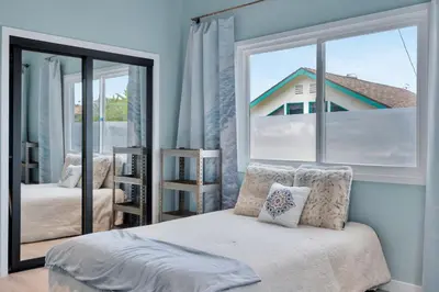 a bedroom with a bed and a large window at NEW BEACH Pool Home, New Industrial OCEAN Vibe, Hot Tub, Pool, Views in El Segundo