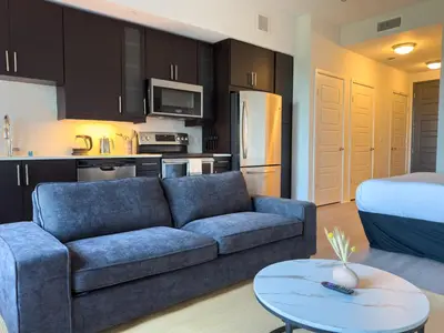 a living room with a couch and a kitchen at City View Suite - DTLA by Monthier in Los Angeles