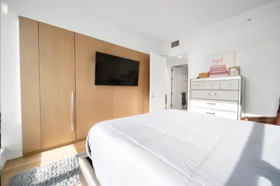 a bedroom with a large white bed and a tv at Lavish High-Rise 2bed Apt in the Hearth of Downtown LA in Los Angeles