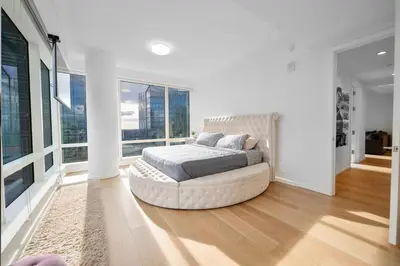a white bedroom with a bed in a room with windows at Lavish High-Rise 2bed Apt in the Hearth of Downtown LA in Los Angeles