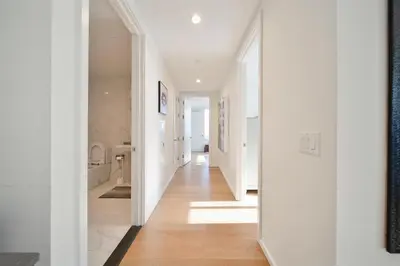 a hallway of a home with white walls and wood floors at Lavish High-Rise 2bed Apt in the Hearth of Downtown LA in Los Angeles