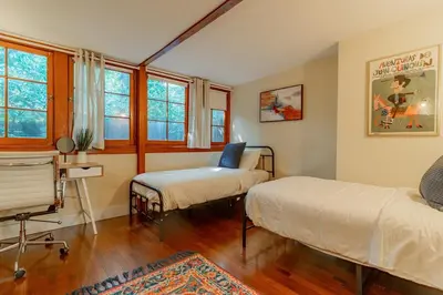 a bedroom with two beds and a chair in it at Cozy 3 Bedroom Hollywood Home- Quick Walk To All Tourist Spots! in Los Angeles