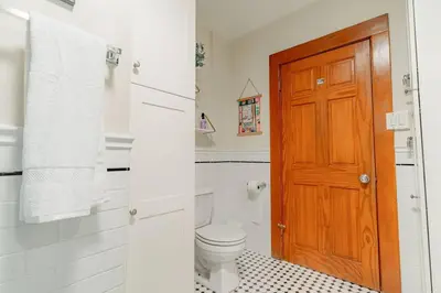 a bathroom with a toilet and a wooden door at Cozy 3 Bedroom Hollywood Home- Quick Walk To All Tourist Spots! in Los Angeles