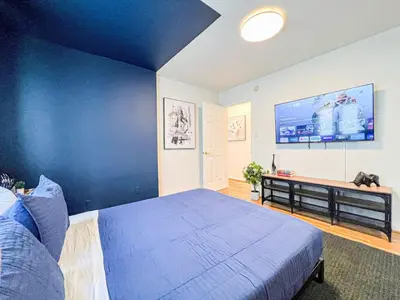 a bedroom with a blue wall with a bed and a television at Diamond in Los Angeles- AM3 in Los Angeles