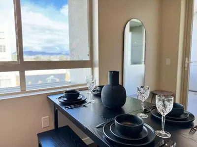 a dining room table with plates and wine glasses at Stylish 1 Bedroom Apartment in LA with Free Parking - 10 Minutes away from Ceders Sinai in Los Angeles