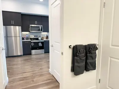 an open door to a kitchen with black cabinets at Modern Hollywood Home Sunset View & Free Parking - 10mins to Universal Studios in Los Angeles