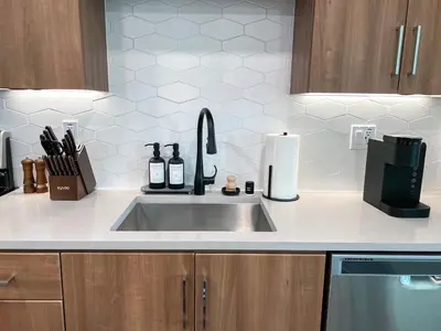 a kitchen counter with a sink with bottles on it at Luxurious Hollywood Home City View - Free Parking 10mins to Universal Studios in Los Angeles