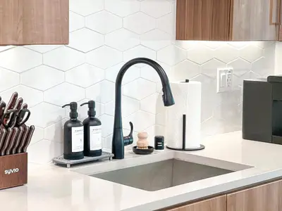 a kitchen sink with two bottles on a counter at Luxurious Hollywood Home City View - Free Parking 10mins to Universal Studios in Los Angeles