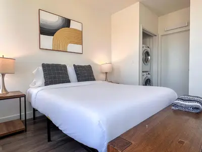 a bedroom with a large white bed and a washing machine at Monthier Downtown SA5S1U0 in Los Angeles