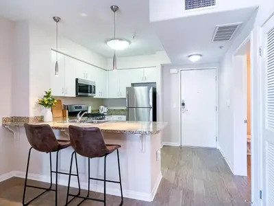a kitchen with white cabinets and a counter with bar stools at Monthier LACMA WI4S4U0 in Los Angeles