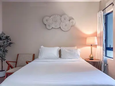 a bedroom with a large white bed and a chair at Monthier LACMA WI4S4U0 in Los Angeles