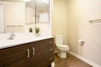 a bathroom with a toilet and a sink with a mirror at Los Angeles Suite LACMA in Los Angeles