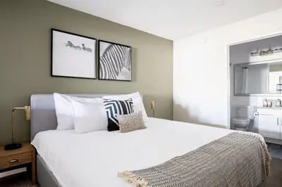 a bedroom with a large white bed with two pictures on the wall at Brentwood Studio w Pool nr UCLA Whole Foods LAX-290 in Los Angeles