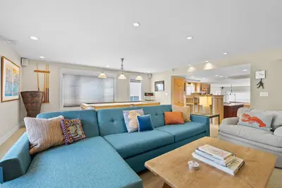a living room with a blue couch and a table at Sand Side Bliss in Oxnard