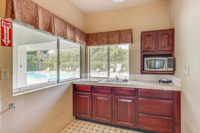 a kitchen with a sink and a microwave and a window at Redlands Home with Community Perks 1 Mi to Downtown in Redlands