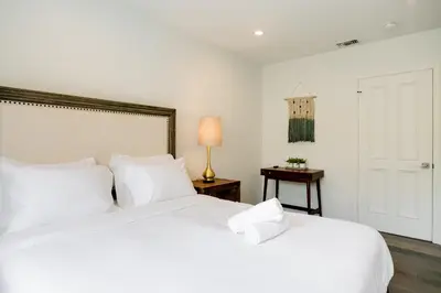 a bedroom with two beds with white sheets and a lamp at Monthier Melrose PO7H2O0 in Los Angeles