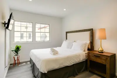 a bedroom with a large white bed with a lamp on a table at Monthier Melrose PO7H2O0 in Los Angeles