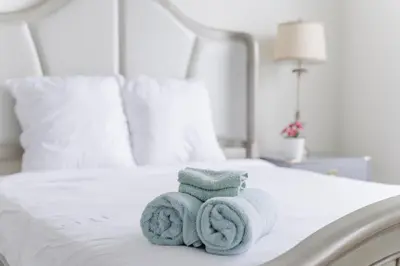 a pile of towels sitting on a bed at Suite Little Tokyo Los Angeles in Los Angeles