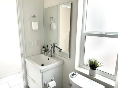a white bathroom with a sink and a mirror at Brand-New Dtla building with rooftop patio in Alhambra
