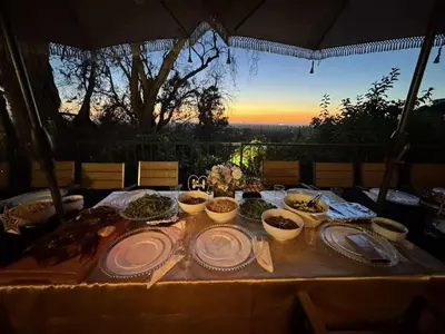 a table with plates and bowls of food on it at Panorama Tropical Resort & Spa with Sunset City View in Santa Ana