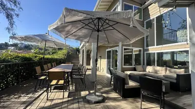 a patio with an umbrella and a table and chairs at Panorama Tropical Resort & Spa with Sunset City View in Santa Ana