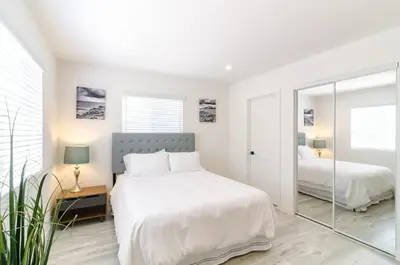 a white bedroom with two beds and a mirror at Sunny 1 Bedroom in the Heart of Venice Beach - 2 in Los Angeles