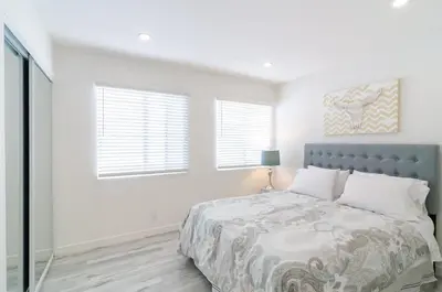 a white bedroom with a bed and two windows at Sunny 1 Bedroom in the Heart of Venice Beach - 2 in Los Angeles